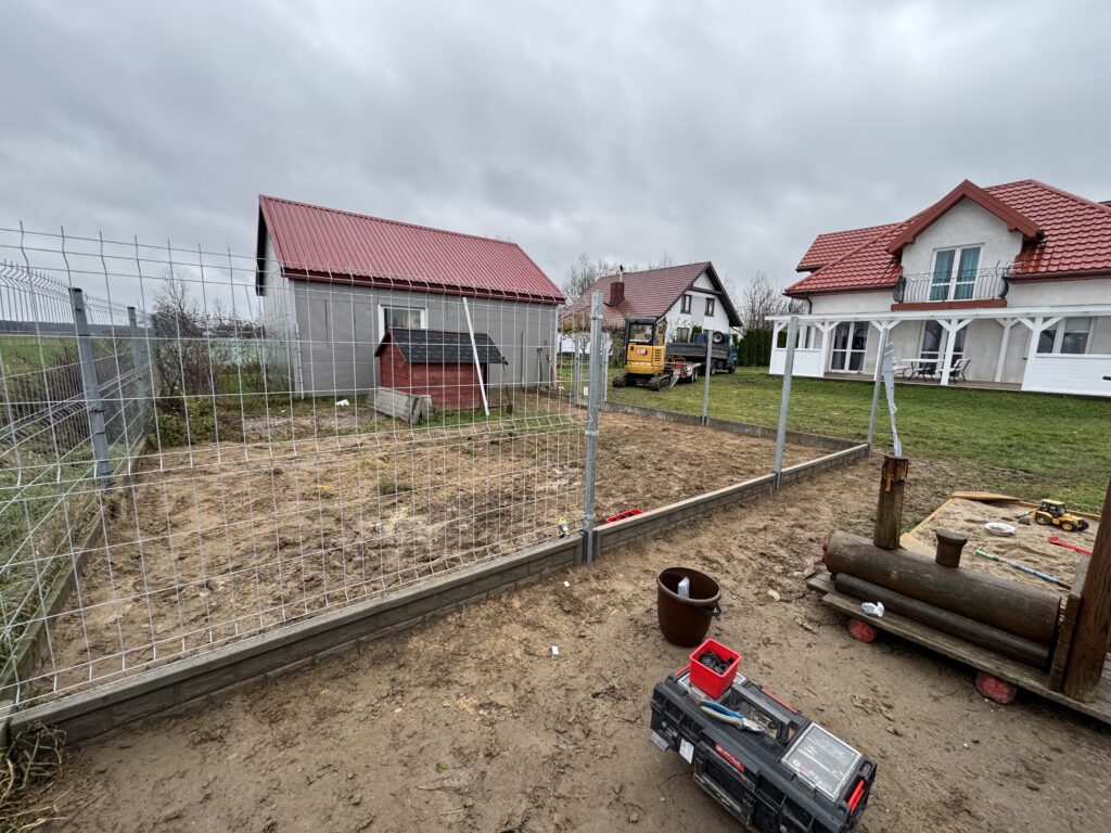 Ogrodzenie panelowe z podmurówką, wykonane z wysokiej jakości materiałów, zamontowane na wyrównanym terenie. Stabilne słupki i solidne przęsła zapewniają trwałość oraz estetykę, odporne na działanie warunków atmosferycznych. Pułtusk, Ciechanów, Płońsk Nasielsk